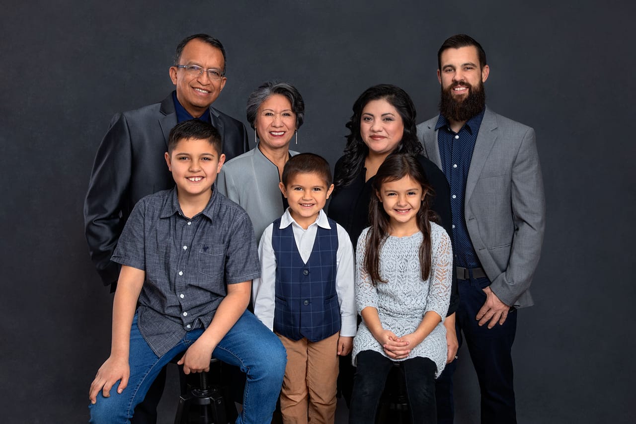 Precious photo of a beautiful, smiling family portrait. Everyone is wearing blues, grays and white. Josh and Stefanie Fraley Family Portrait Photography.