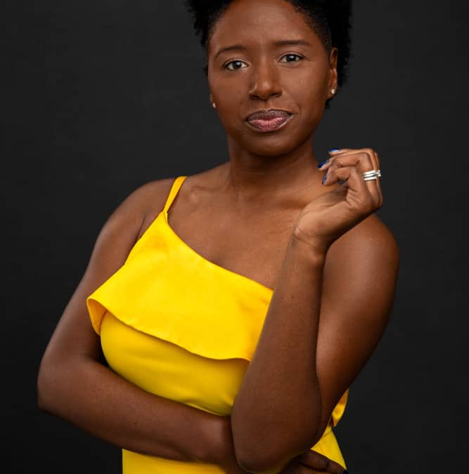 Mid cropped branding photo of a stylish, pretty black woman with yellow dress posing like a boss lady. Tiffane Davis of A Polished Man during personal branding photo session.