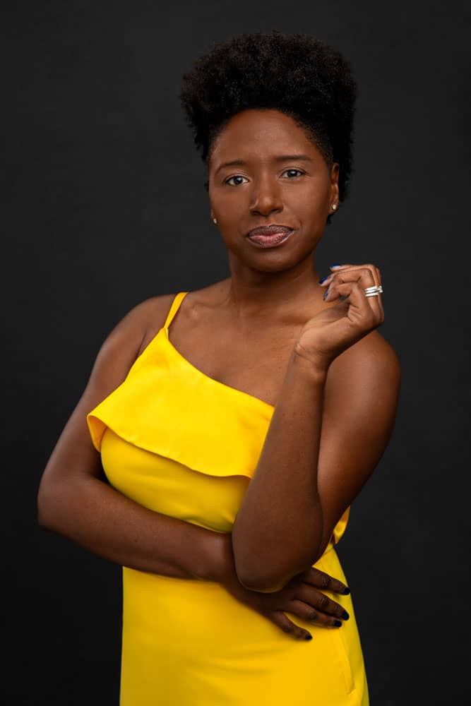 Mid cropped branding photo of a stylish, pretty black woman with yellow dress posing like a boss lady. Tiffane Davis of A Polished Man during personal branding photo session.